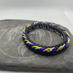 A chainmaille bracelet made with the persian 4 in 1 weave. This bracelet represents the Non-Binary Pride flag. It is made of black EPDM rings, and purple, silver, and yellow anodized aluminium rings.