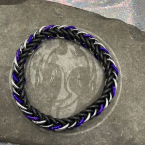 A chainmaille bracelet made with the persian 4 in 1 weave. This bracelet represents the Asexual Pride flag. It is made of black EPDM rings, and silver, gunmetal gray, and purple anodized aluminium rings.