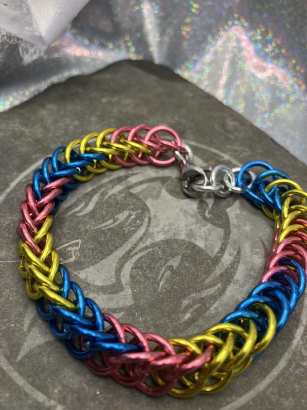 Bracelet woven in the persian 4 in 1 weave using the colors of the Pansexual Pride Flag, pink, yellow, and blue.